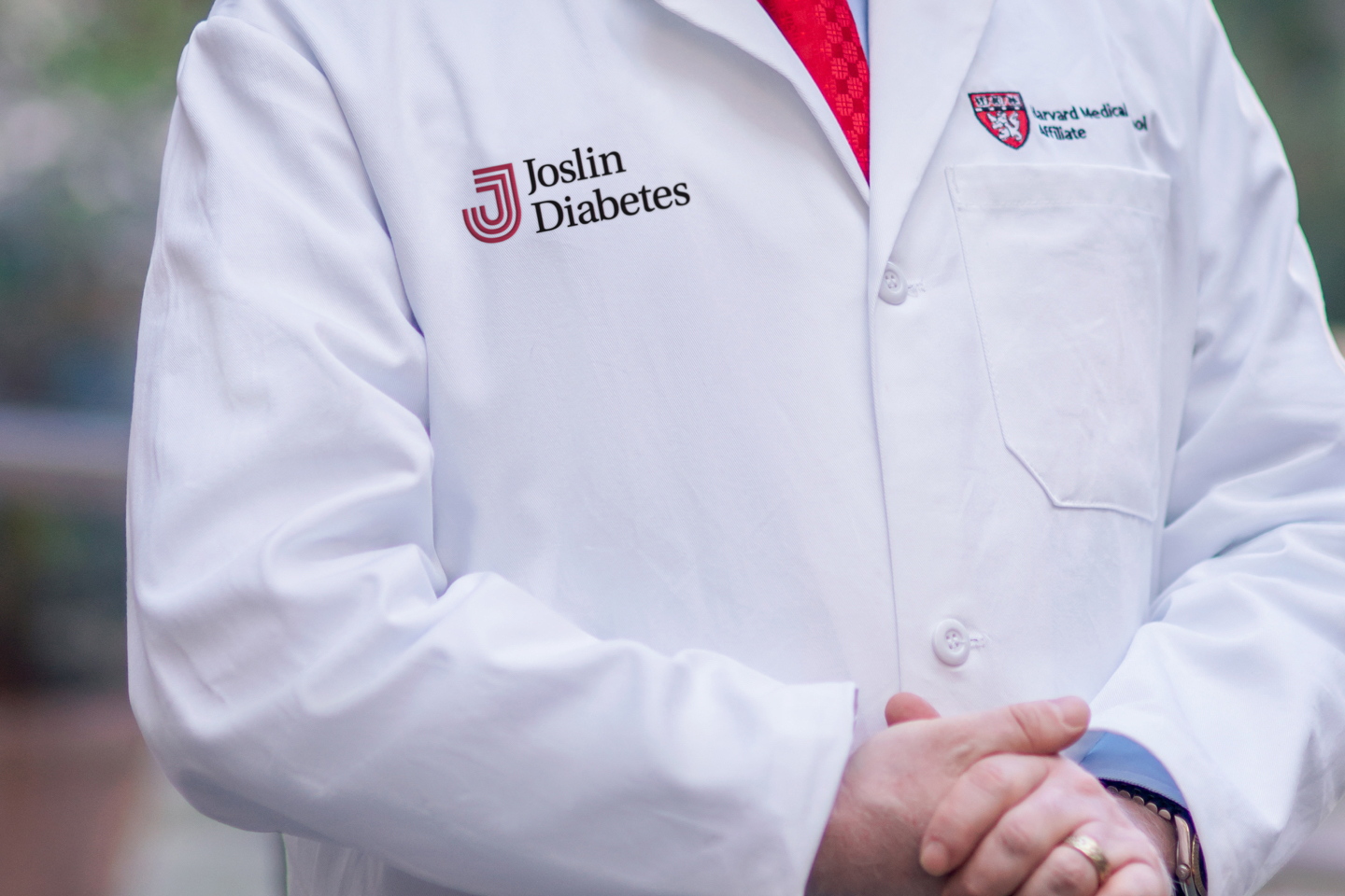 A close up of a doctor in a white coat with the Joslin logo.